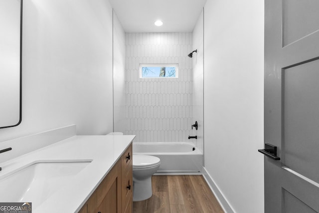 bathroom featuring baseboards, toilet, shower / tub combination, wood finished floors, and vanity