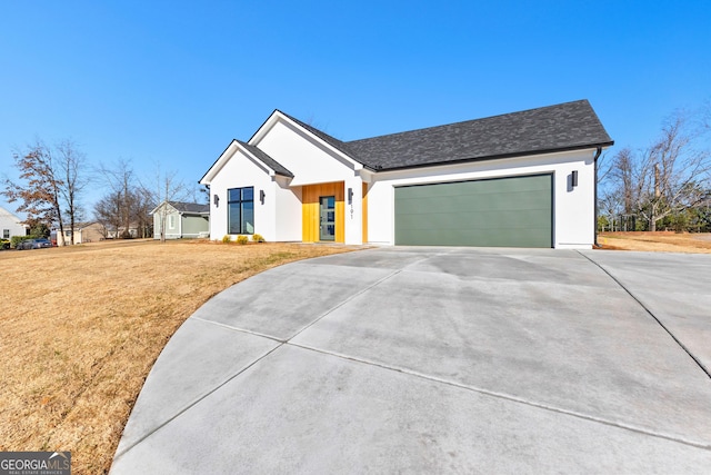 modern farmhouse style home with a shingled roof, a front yard, driveway, and an attached garage