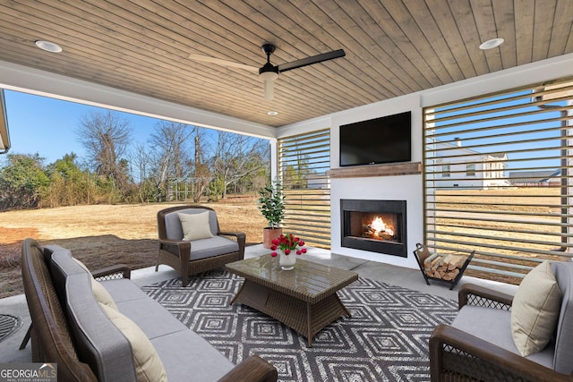 view of patio / terrace featuring ceiling fan and an outdoor living space with a fireplace