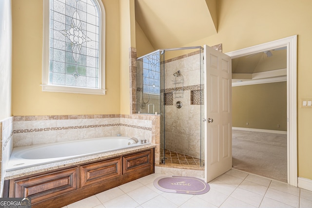 bathroom with separate shower and tub, lofted ceiling, and tile patterned floors