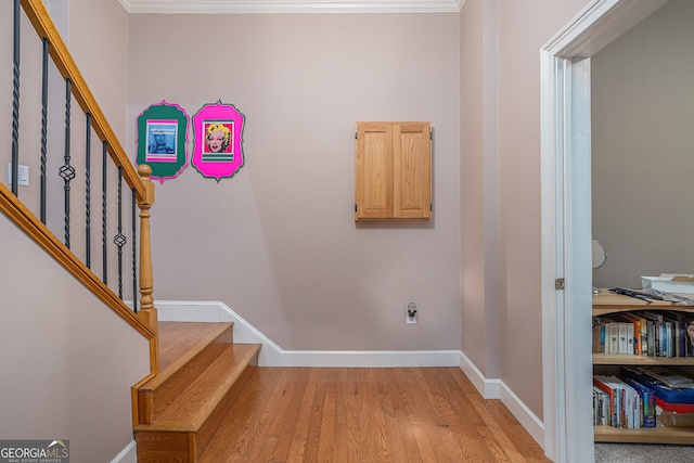 stairway featuring crown molding and hardwood / wood-style flooring