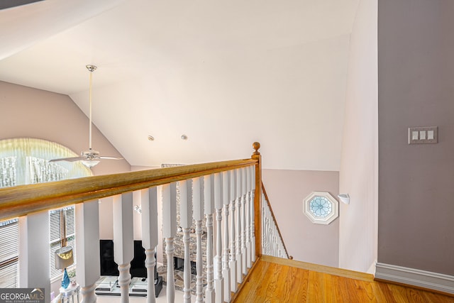 stairway featuring wood-type flooring, lofted ceiling, and ceiling fan