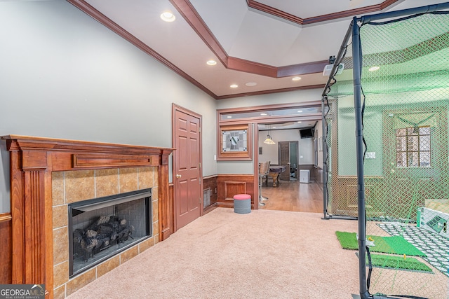 living room featuring crown molding, carpet, and a tiled fireplace