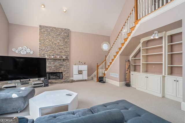 carpeted living room with a high ceiling and a fireplace