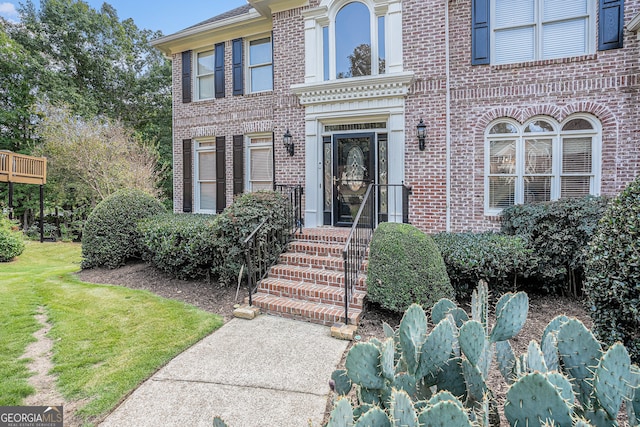 view of exterior entry with a yard