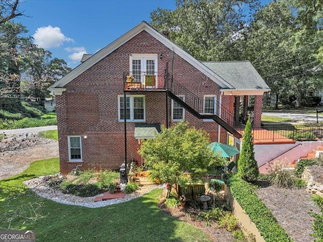 view of home's exterior with a balcony and a yard