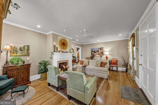 living room with crown molding, light wood-type flooring, and ceiling fan