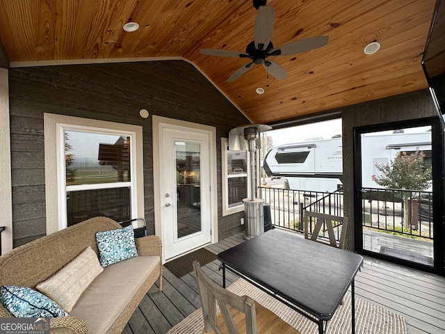 sunroom / solarium with wood ceiling, vaulted ceiling, and ceiling fan