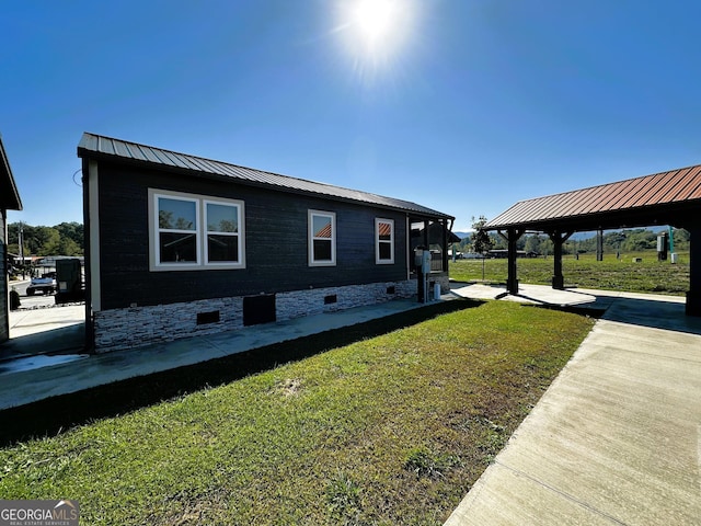 view of side of property with crawl space, a gazebo, metal roof, and a lawn