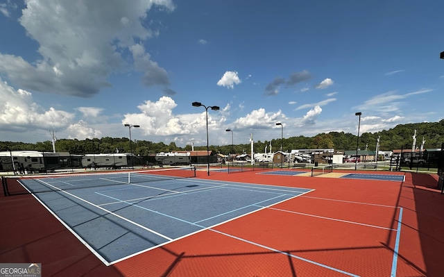 view of tennis court with community basketball court and fence