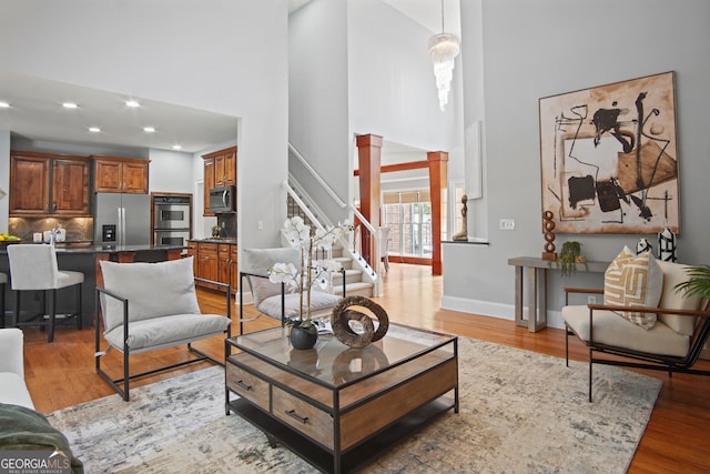 living room featuring a towering ceiling and light hardwood / wood-style floors