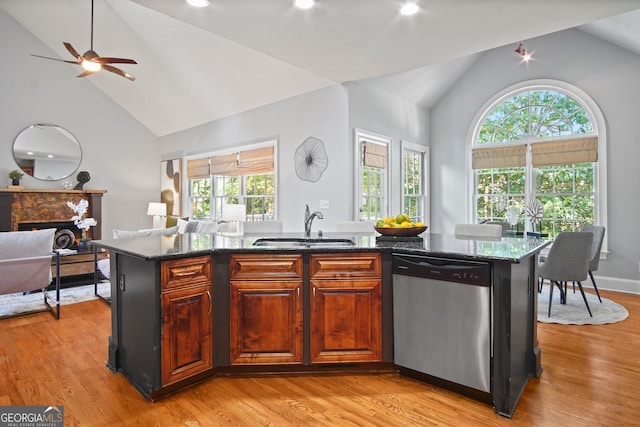 kitchen with a center island with sink, light hardwood / wood-style floors, dishwasher, and plenty of natural light