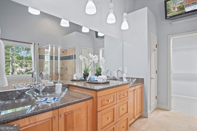 bathroom featuring walk in shower, vanity, and tile patterned flooring