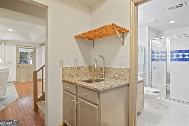 kitchen featuring light stone counters, light hardwood / wood-style flooring, and sink