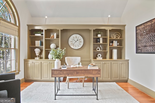 office space with light wood-type flooring and vaulted ceiling