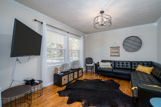 living room featuring a textured ceiling, wood-type flooring, ornamental molding, and a notable chandelier