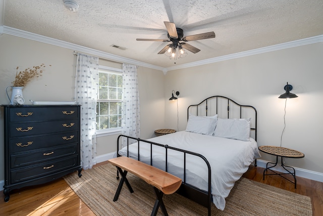 bedroom featuring a textured ceiling, ceiling fan, hardwood / wood-style floors, and crown molding