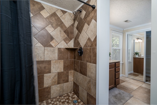 bathroom featuring a shower with curtain, vanity, a textured ceiling, ornamental molding, and tile patterned floors