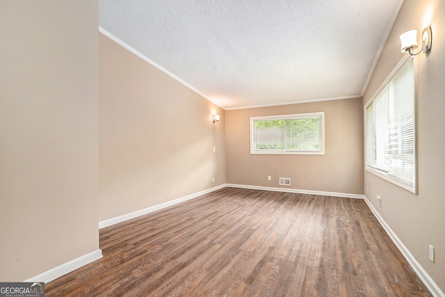 unfurnished room with a textured ceiling, crown molding, and dark hardwood / wood-style floors