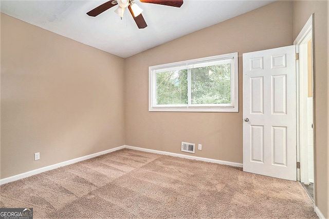 carpeted spare room with vaulted ceiling and ceiling fan