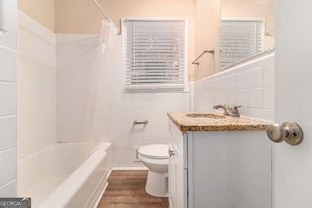 full bathroom with hardwood / wood-style flooring, toilet, shower / bath combo with shower curtain, vanity, and tile walls