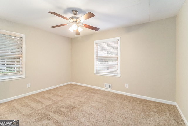 carpeted empty room with a healthy amount of sunlight and ceiling fan