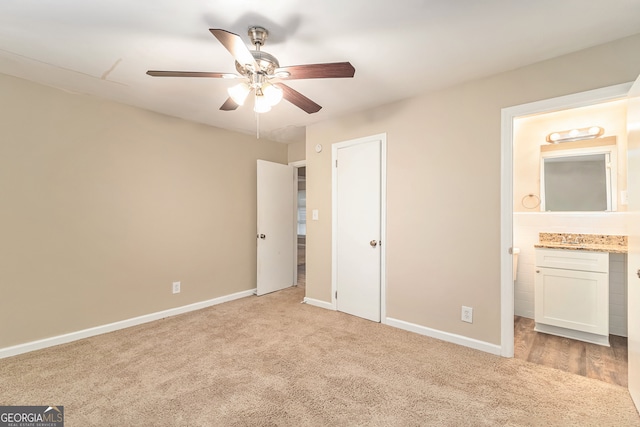 unfurnished bedroom featuring light carpet, connected bathroom, and ceiling fan