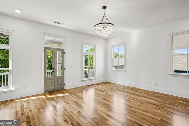 interior space featuring an inviting chandelier, light wood-type flooring, and a wealth of natural light