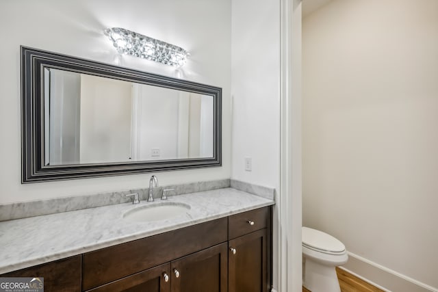 bathroom featuring hardwood / wood-style flooring, vanity, and toilet