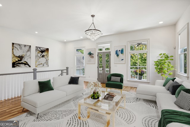 living room featuring hardwood / wood-style floors, an inviting chandelier, and a healthy amount of sunlight