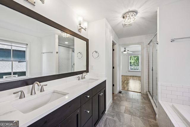 bathroom featuring shower with separate bathtub, a notable chandelier, and vanity