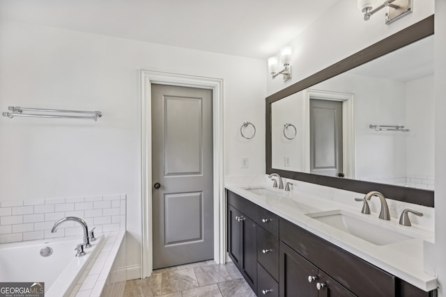 bathroom featuring tiled tub and vanity