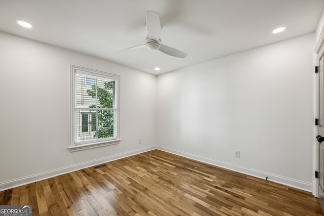 spare room featuring wood-type flooring and ceiling fan