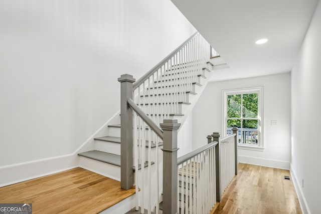 staircase with hardwood / wood-style floors