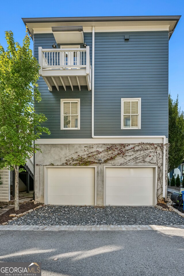 view of front facade featuring a balcony and a garage