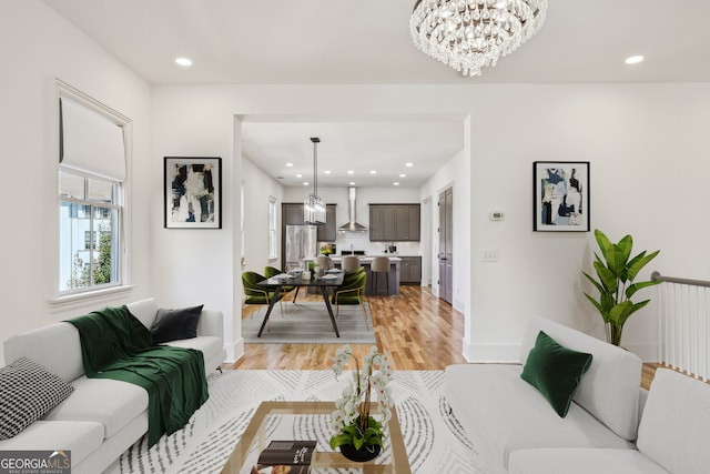 living room with a notable chandelier and light wood-type flooring