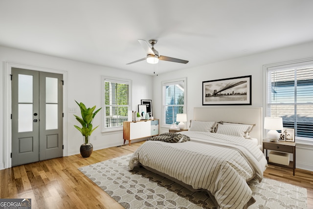 bedroom with ceiling fan, light hardwood / wood-style flooring, and french doors