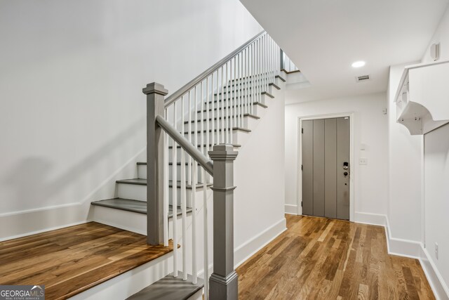 stairway featuring wood-type flooring