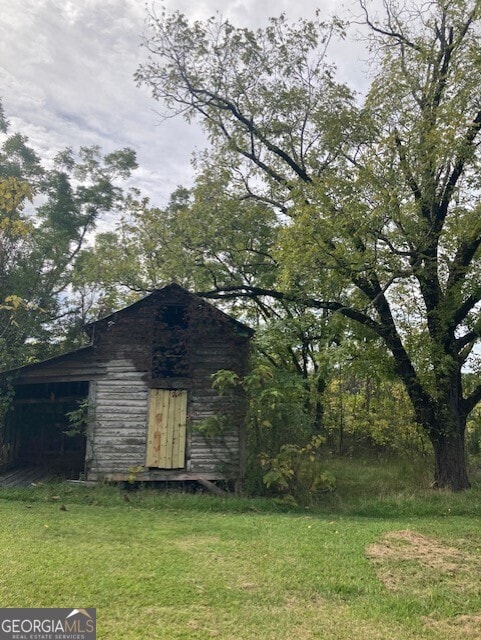 view of property exterior featuring an outbuilding and a yard