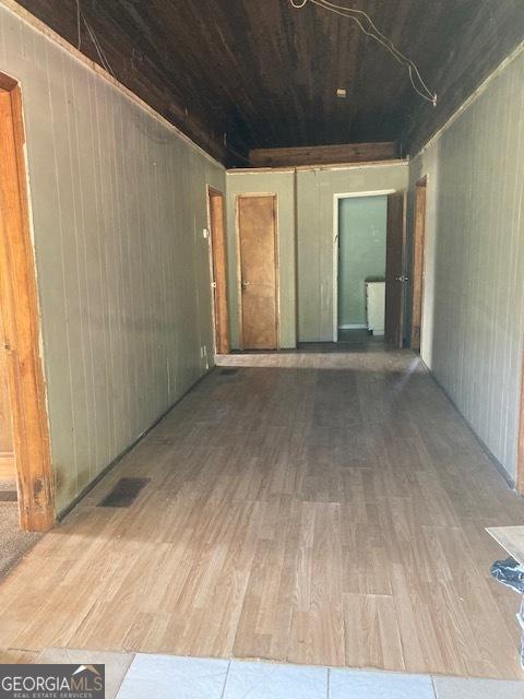 empty room with hardwood / wood-style floors and wood walls