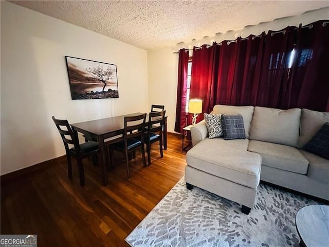 living room featuring a textured ceiling and dark hardwood / wood-style flooring