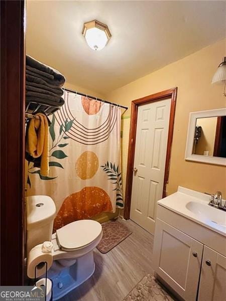 bathroom featuring a shower with curtain, vanity, toilet, and hardwood / wood-style flooring