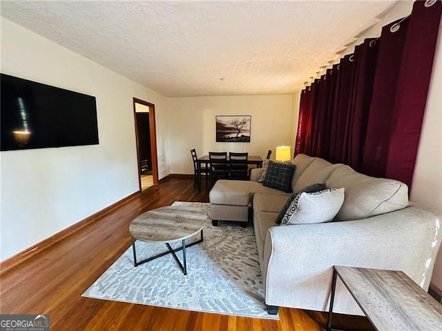 living room with a textured ceiling and hardwood / wood-style floors