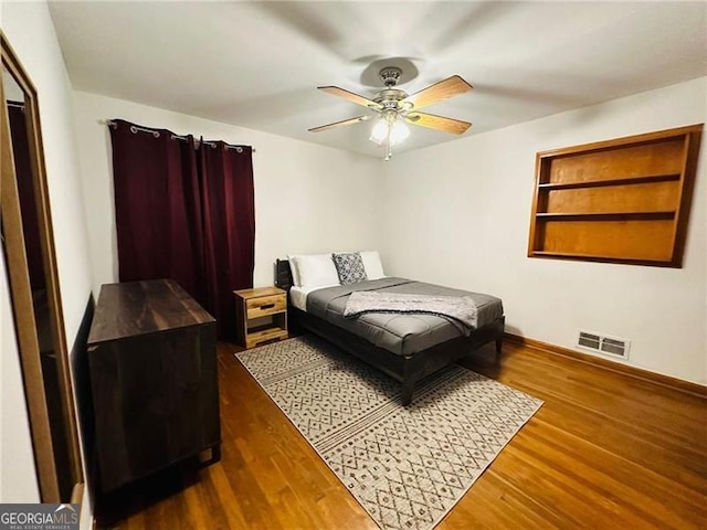 bedroom with ceiling fan and dark hardwood / wood-style flooring