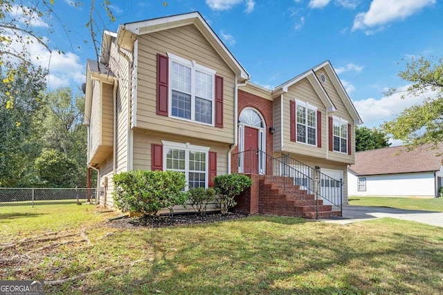 bi-level home with a garage and a front lawn