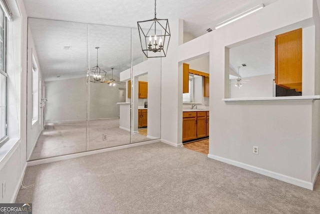 interior space featuring ceiling fan with notable chandelier, a wealth of natural light, and sink