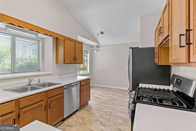 kitchen featuring appliances with stainless steel finishes, lofted ceiling, sink, and ceiling fan