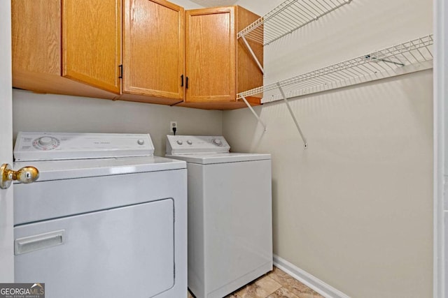 washroom featuring cabinets and washer and dryer