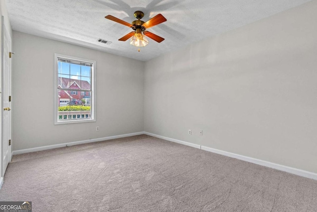 empty room featuring a textured ceiling, carpet floors, and ceiling fan