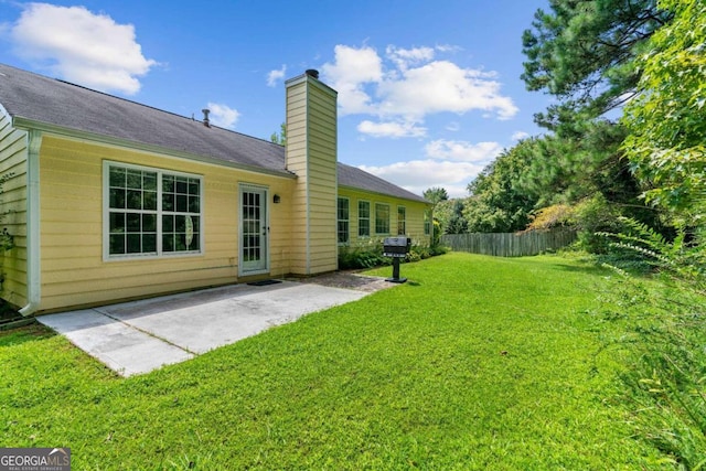 back of property with a lawn and a patio